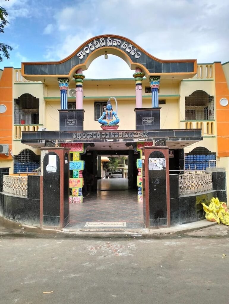 Entrance gate of Reddy Satham in Srisailam, featuring a colorful archway with Telugu lettering and a seated Shiva statue above the gateway.